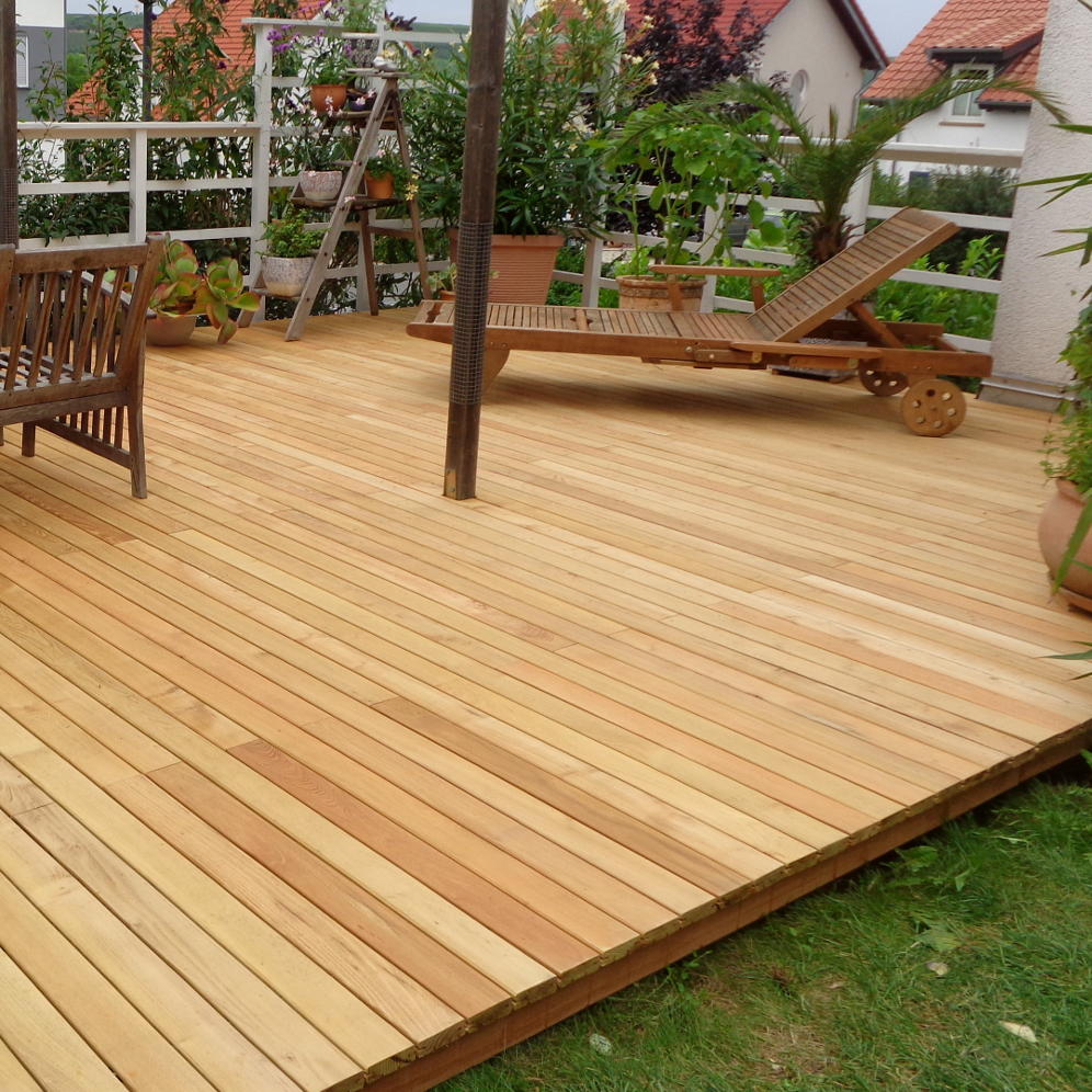 Eine Terrasse aus Robinie-Dielen mit Gartenmöbeln aus dunklem Holz