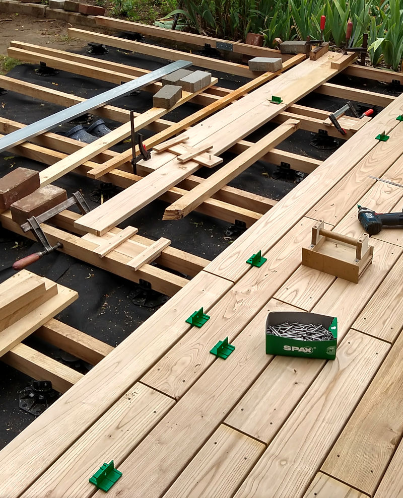 Auf Unterkonstruktionshölzern werden Kastanie-Terrassendielen mit hilfe von Dielen-Abstandshalter, Terrassenschrauben und Akku-Schraubern verschraubt.